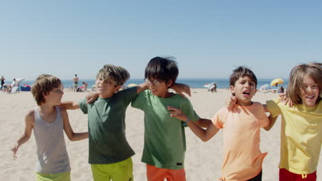 Slider-shot-of-happy-kids-hugging-and-jumping-on-sandy-beach